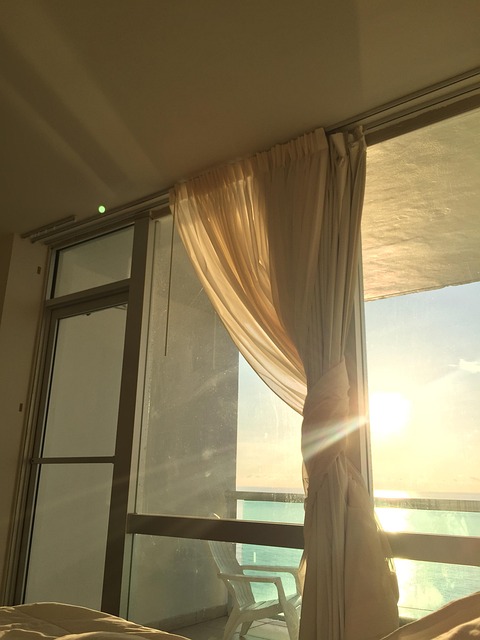 Warm sunrise light coming through curtains in a bedroom window